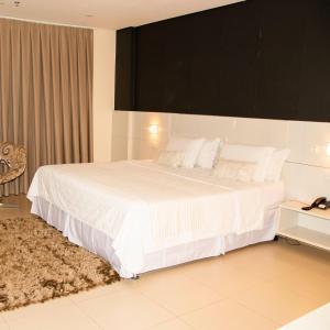 波多韦柳金座大酒店 的卧室配有一张带白色床单和枕头的大床。