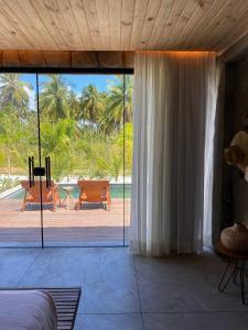 佩德拉斯港Pedras Do Patacho Hotel Boutique Experience的一间卧室设有大型滑动玻璃门和庭院