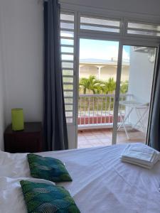 勒沃克兰Les plages de Macabou的一间卧室设有一张床,享有阳台的景色