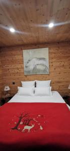 丰罗穆Le Renne Blanc Pyrénées de France的一间卧室配有一张带红色毯子的床