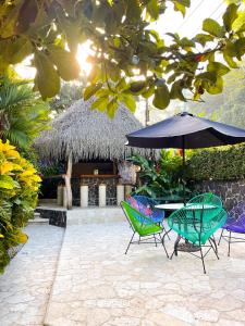 坦波Hotel Costa Coral的庭院配有椅子和桌子及遮阳伞