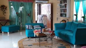 鲁滕D-Rima Homestay Ruteng的客厅配有2张蓝色的沙发和1张桌子