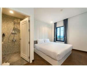 拉差汶里Nine River Hotel的卧室配有白色的床和淋浴