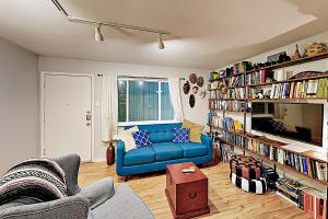 奥斯汀Creekside Terrace Condominiums #211的客厅配有蓝色的沙发和书架