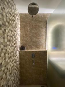 日惹The yudhistira apartment的带淋浴的浴室(带石墙)