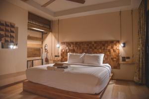 清迈盖特佳村酒店的卧室配有一张白色大床和砖墙
