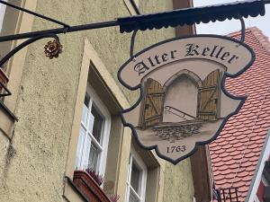 罗滕堡Gästehaus Alter Keller的建筑一侧的标志,带有窗户