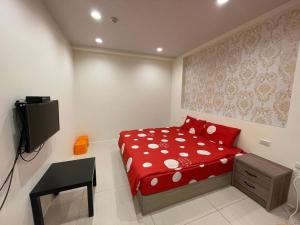罗东镇羅東珍寶的一间设有红色床和电视的小卧室