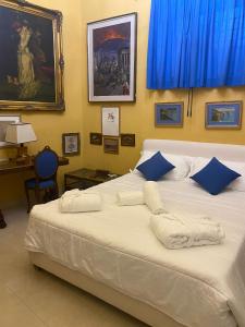 伊斯基亚Sunlux Maison的卧室配有带蓝色枕头的大型白色床