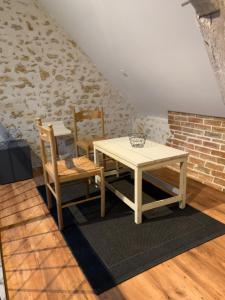 ParenceChambre en campagne的砖墙间里一张桌子和两把椅子