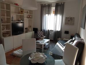 比耶拉Casa MaCrì Biella的客厅配有桌子和电视