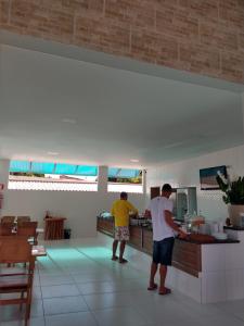 拉巴拉德纳圣安东尼奥Paraiso Barra Hotel的两个人站在厨房准备食物