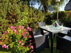 卡珀尔恩诗莱门德酒店的花园里的桌椅,花朵粉红色