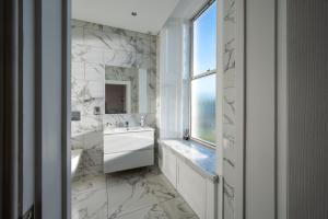 布罗迪菲利Casa Fresa - Orchar Suites的带浴缸、水槽和窗户的浴室
