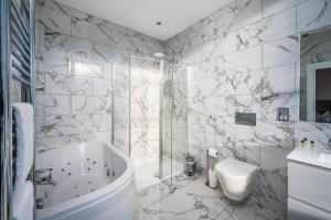 布罗迪菲利Casa Fresa - Orchar Suites的带浴缸、卫生间和盥洗盆的浴室