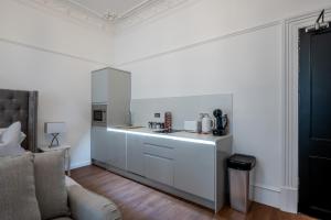 布罗迪菲利Casa Fresa - Orchar Suites的一间厨房,内设白色橱柜和沙发