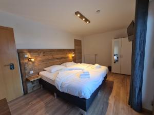 玛丽亚阿尔姆Hotel Pension Annerlhof的一间卧室配有一张大床和木制床头板