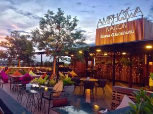安帕瓦Amphawa Nanon Hotel的一个带桌椅的户外庭院和一间餐厅