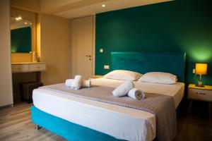 斯沃伦塔Paporas Apartments的一间卧室设有两张床和绿色的墙壁