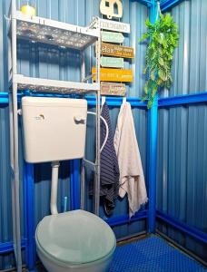 PendangEmbun Desa Homestay, Pendang, Kedah的浴室设有蓝色墙壁内的卫生间