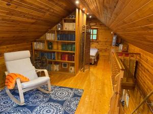 特拉凯蜂蜜浴度假屋的客厅配有椅子和书架