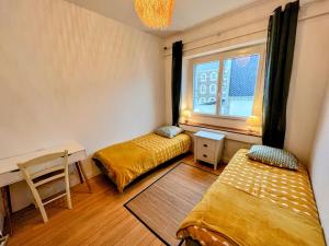 南特Appartement de Charme de 75m², Lumineux et Calme的客房设有两张床、一张桌子和一个窗户。