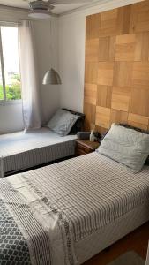 瓜鲁柳斯Quartos Vila Augusta/Guarulhos的小型客房 - 带2张床和窗户