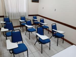 乌鲁瓜亚纳Hotel Monte Carlo的一个空的教室,里面摆放着蓝色的椅子和书桌