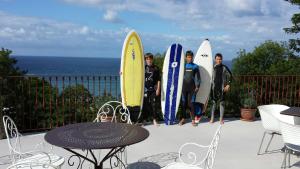 雷凯蒂奥伊特萨索别墅的一群冲浪者站在一个配有冲浪板的阳台