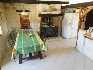 LimalongesChatenet self catering stone House for 2 South West France的厨房配有桌子、冰箱和炉灶。