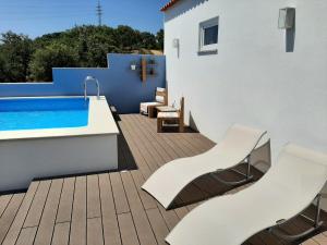 圣地亚哥-杜卡森Herdade de Vale Maceiras的一个带白色椅子的甲板和游泳池