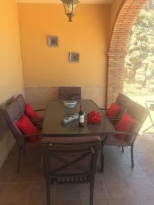 AlmogíaCasa Cuatro Vientos - Barranco Del Sol的桌椅和一瓶葡萄酒