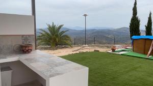 AlmogíaCasa Cuatro Vientos - Barranco Del Sol的后院设有绿色草坪,享有山景