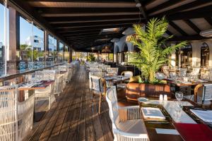 普拉亚布兰卡Hotel LIVVO Volcán Lanzarote的一间设有白色桌椅的餐厅,享有美景。