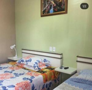 拉热斯Pousada Nativa Lages的卧室配有一张床和一张桌子,墙上挂着一张照片