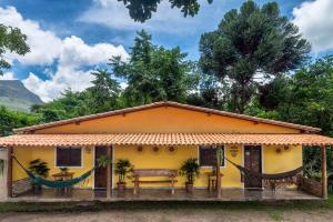 韦尔卡鲍Pousada Aconchego的前面有长凳的黄色房子