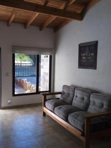 埃斯克尔Duplex Patagonia的客厅设有一张沙发,配有大窗户