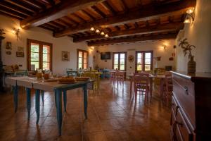 斯卡尔利诺Agriturismo La Banchella的大型厨房以及带桌椅的用餐室
