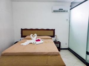 纳塔尔Marlymar Apart Pousada的一间卧室配有一张带两只天鹅的毛巾床