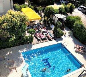 里乔内Hotel Marzia con Piscina的游泳池的顶部景色,里面的人