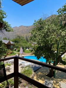 圣何塞德迈波Refugio del Maipo Lodge的从房子的阳台上可欣赏到游泳池的景色