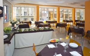 里米尼奥地利酒店的用餐室设有桌椅和窗户。
