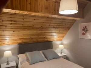 萨拉尔杜Eth Céu de Salardú的一间卧室配有一张木墙床