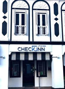 新加坡Check-Inn at Little India的黑白的建筑,有校验表的标志