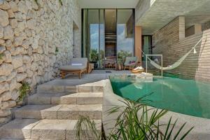 普拉亚卡门La Casa de la Playa by Xcaret- All Inclusive Adults Only的一座房子,设有游泳池,毗邻石墙