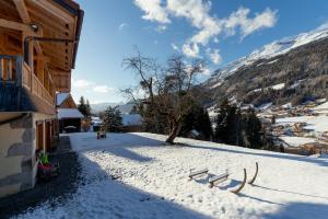 Les Villards-sur-ThônesLes Picaillons - Le Chalet的一座有积雪覆盖的院子,有一座建筑和一座山