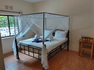卡拉图Tanzanice Farm Lodge的一间卧室配有一张带天蓬的床