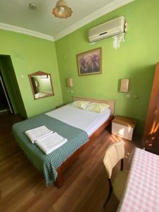安塔利亚Camel Hotel & Apart的绿色卧室配有床和镜子