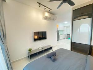 努沙再也Teega Suites, Puteri Harbour, Iskandar Puteri的一间卧室配有一张床和一台平面电视