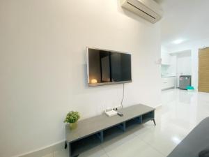 努沙再也Teega Suites, Puteri Harbour, Iskandar Puteri的一间客厅,客厅的白色墙壁上配有电视